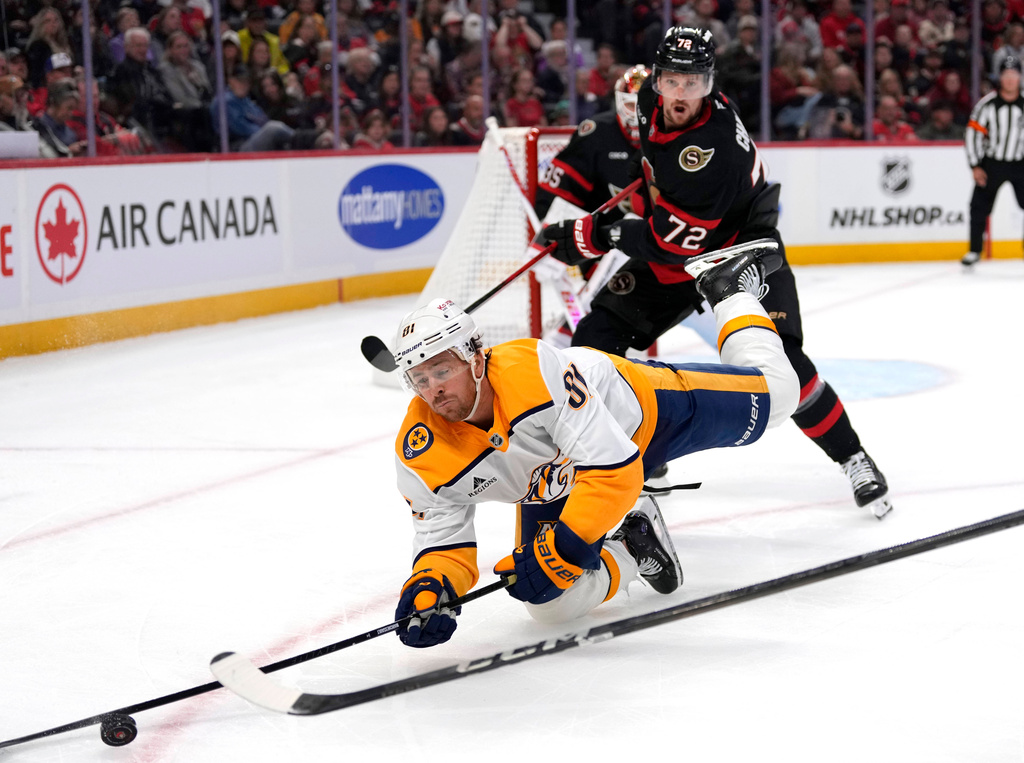 Nashville Predators' Jonathan Marchessault (81) falls in front of Ottawa Senators' Thomas Chabot (72) as they chase the puck during first period NHL hockey action in Ottawa, Monday, Oct. 13, 2025. (Justin Tang/The Canadian Press via AP)