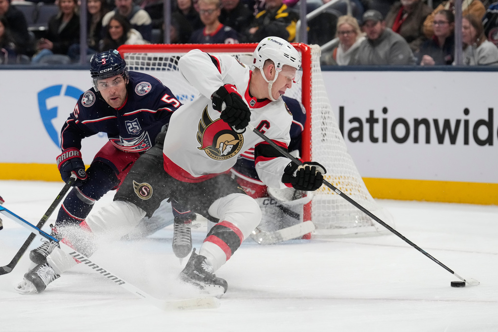Ottawa Senators left wing Brady Tkachuk, right, skates in front of Columbus Blue Jackets defenseman Denton Mateychuk (5) in the second period of an NHL hockey game Thursday, Dec. 11, 2025, in Columbus, Ohio. (AP Photo/Sue Ogrocki)