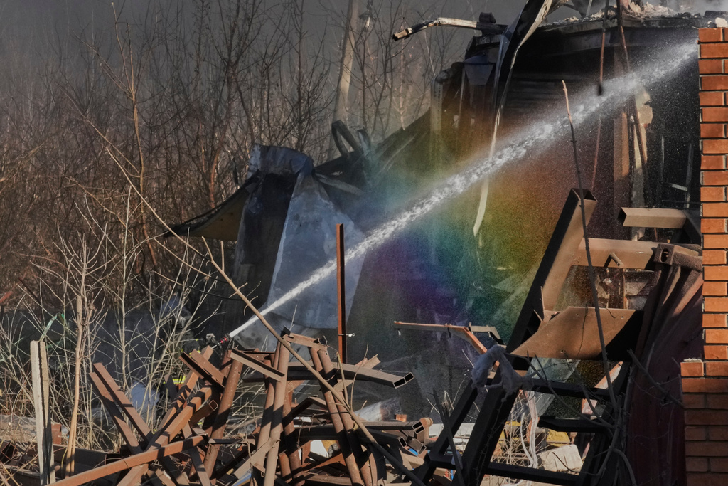 Firefighters put out the fire at railway workshops following a Russia missile and drone attack, in Brovary close to Kyiv, Ukraine, Saturday, March 14, 2026. (AP Photo/Efrem Lukatsky)