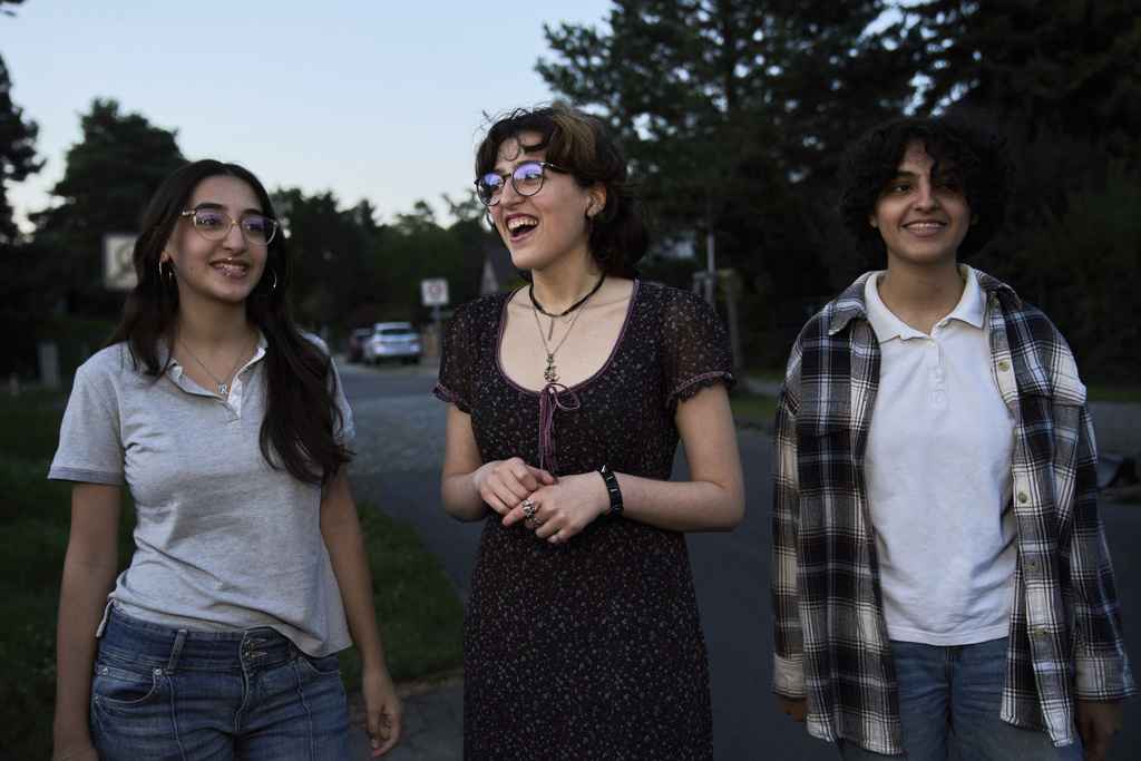 Sisters Razan Wahbeh, 17, Rajaa Wahbeh, 20, and Raneen Wahbeh, 13, hang out in front of their house in Berlin on Aug. 25, 2025. (AP Photo/Ebrahim Noroozi)