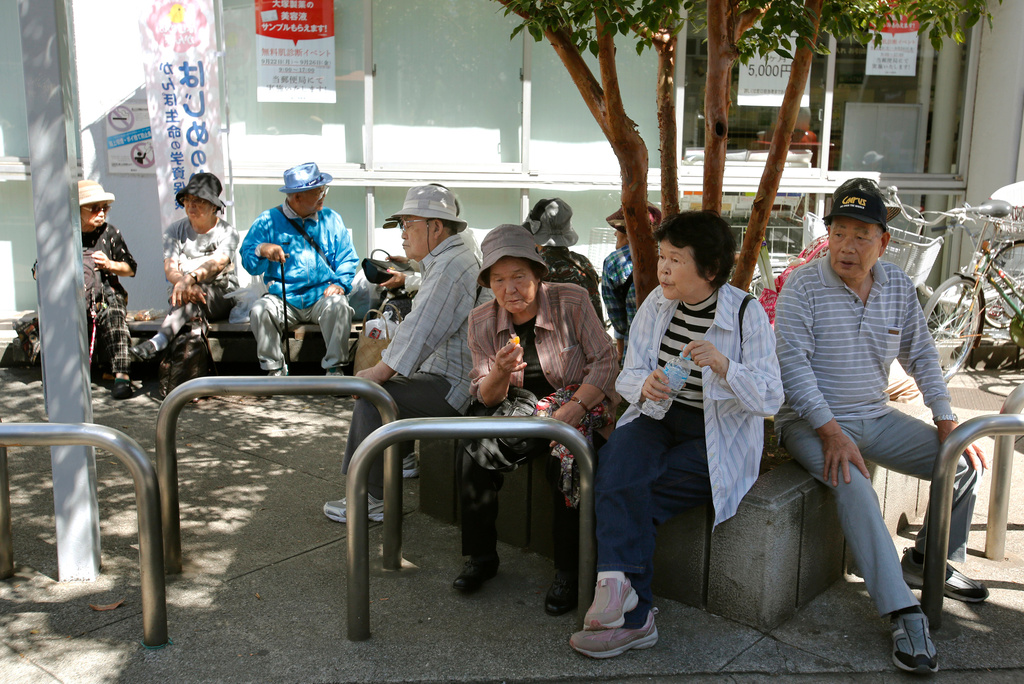 Elderly people rest under the shade of a tree in Tokyo, Sunday, Sept. 14, 2014. (AP Photo/Shizuo Kambayashi, File)