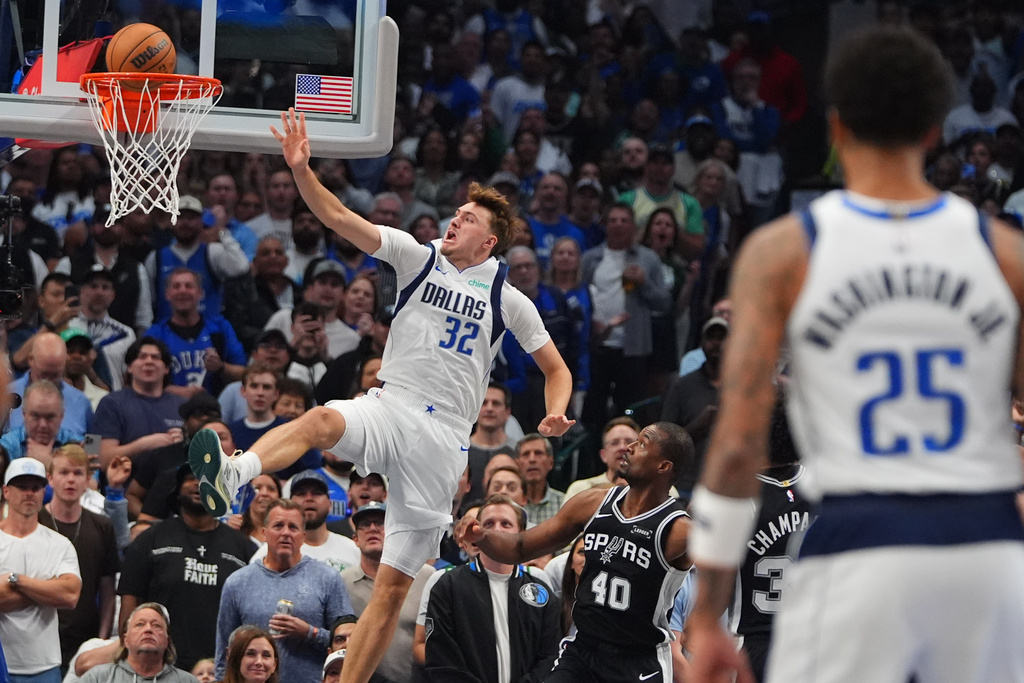 Dallas Mavericks forward Cooper Flagg (32) shoots against San Antonio Spurs forward Harrison Barnes (40) during the first half of an NBA basketball game in Dallas, Wednesday, Oct. 22, 2025. (AP Photo/LM Otero)