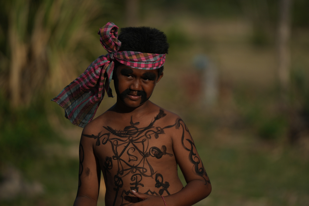 A boy with a ghost painting takes part in a ceremony to invoke rain amid the rice planting season in Pring Ka-ek village, northwest of Phnom Penh, Cambodia, Thursday, May 21, 2026. (AP Photo/Heng Sinith)