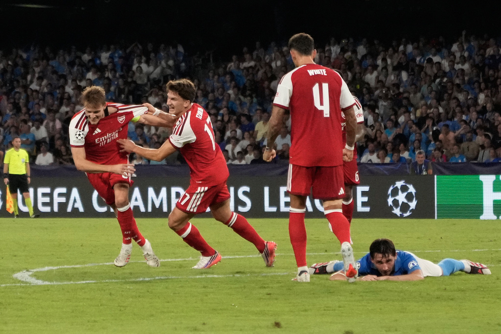 Arsenal's Martin Odegaard, left, celebrates with Arsenal's Christos Tzolis after scoring the opening goal during their Champions League soccer match between Napoli and Arsenal, in Naples, southern Italy, Wednesday, Sept. 9, 2026. (AP Photo/Gregorio Borgia)
