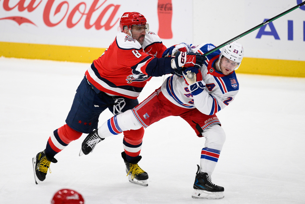 Washington Capitals left wing Alex Ovechkin (8) battles with New York Rangers defenseman Adam Fox (23) during the third period of an NHL hockey game, Wednesday, Dec. 31, 2025, in Washington. (AP Photo/Nick Wass)
