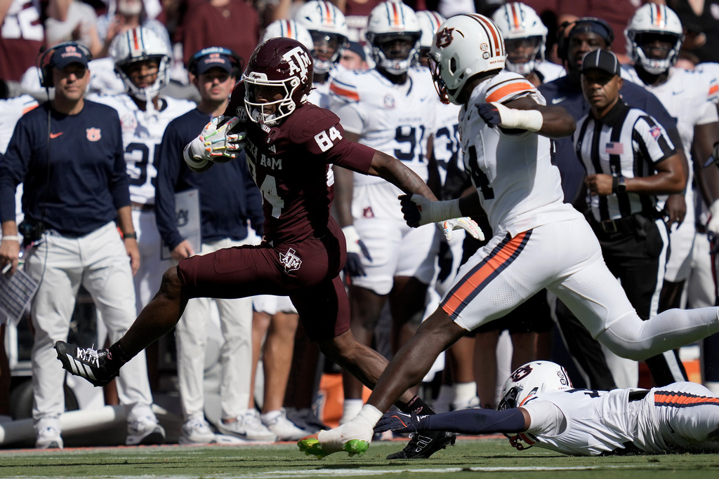 Texas A&M tight end Amari Niblack, left, steps out of a tackle attempt before being tackled by Auburn defensive end Keyron Crawford, right, after a long catch and run play during the first half of an NCAA college football game Saturday, Sept. 27, 2025, in College Station, Texas. (AP Photo/Sam Craft)
