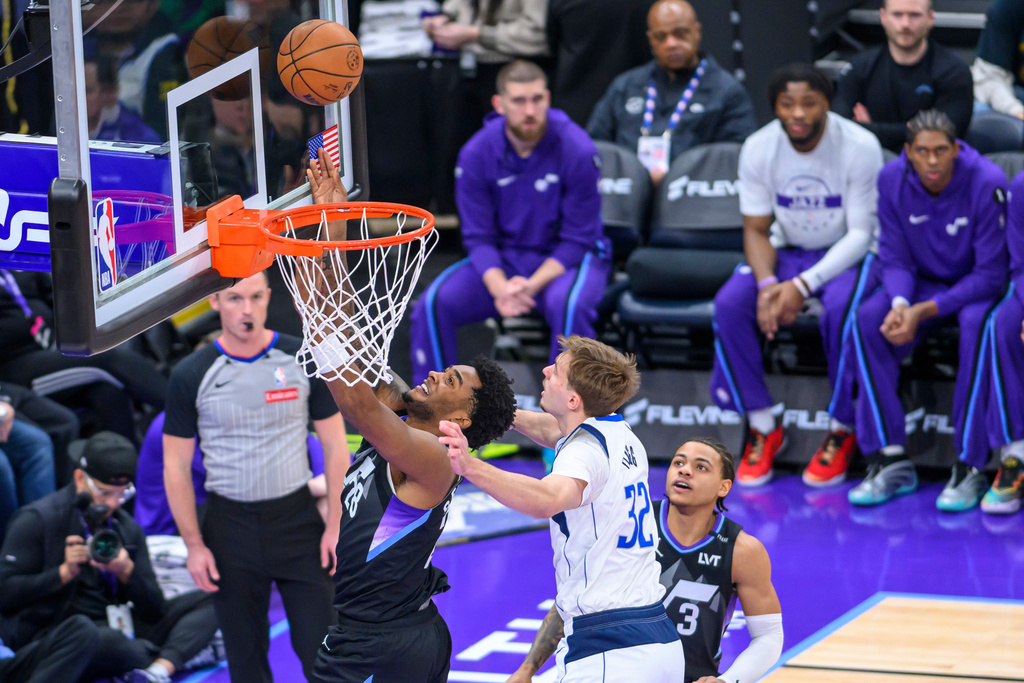 Utah Jazz forward Brice Sensabaugh (28) plays the ball off the glass while guarded by Dallas Mavericks forward Cooper Flagg (32) during the first half of an NBA basketball game, Monday, Dec. 15, 2025, in Salt Lake City. (AP Photo/Tyler Tate)