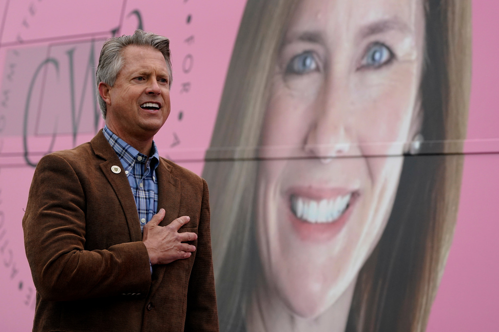 FILE - Rep. Roger Marshall, R-Kan., stands for the national anthem in front of photo of Supreme Court nominee Amy Coney Barrett while attending a Concerned Women for America event outside a gun store in Kansas City, Kan. Wednesday, Oct. 21, 2020. (AP Photo/Charlie Riedel, File)