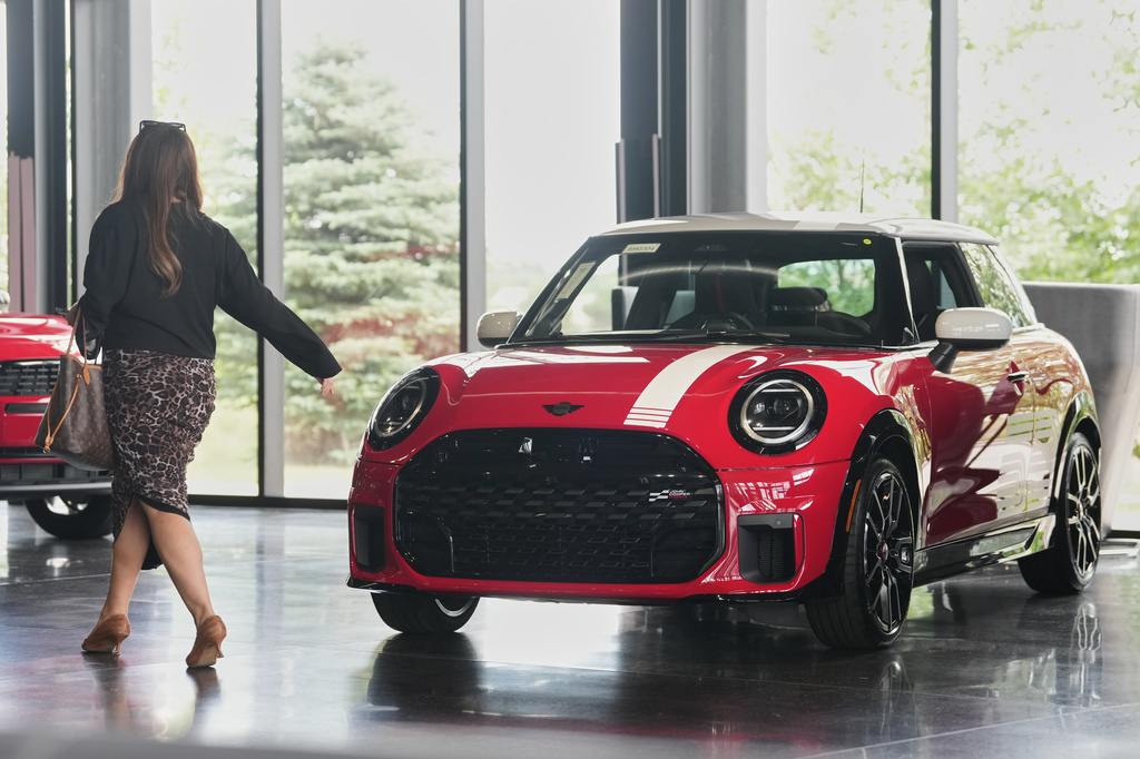 FILE - A shopper passes by an unsold 2026 Cooper S John Cooper Works 1965 Victory Edition hardtop on display in the showroom of a Mini dealership Friday, June 26, 2026, in Highlands Ranch, Colo. (AP Photo/David Zalubowski, File)