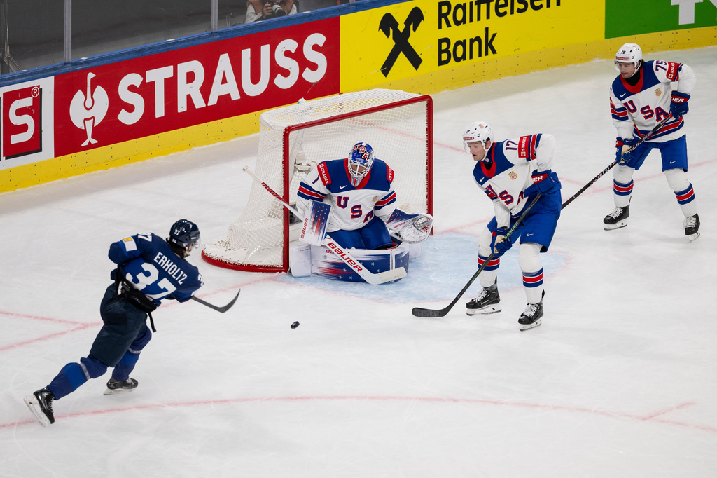 Finland's Eemil Erholtz, left, shoots on goal against USA's goaltender Devin Cooley, Will Borgen and Connor Clifton, right, during the Men's Ice Hockey World Championship preliminary round game between Finland and the USA in Zurich, Switzerland, Monday, May 18, 2026. (Andreas Becker/Keystone via AP)