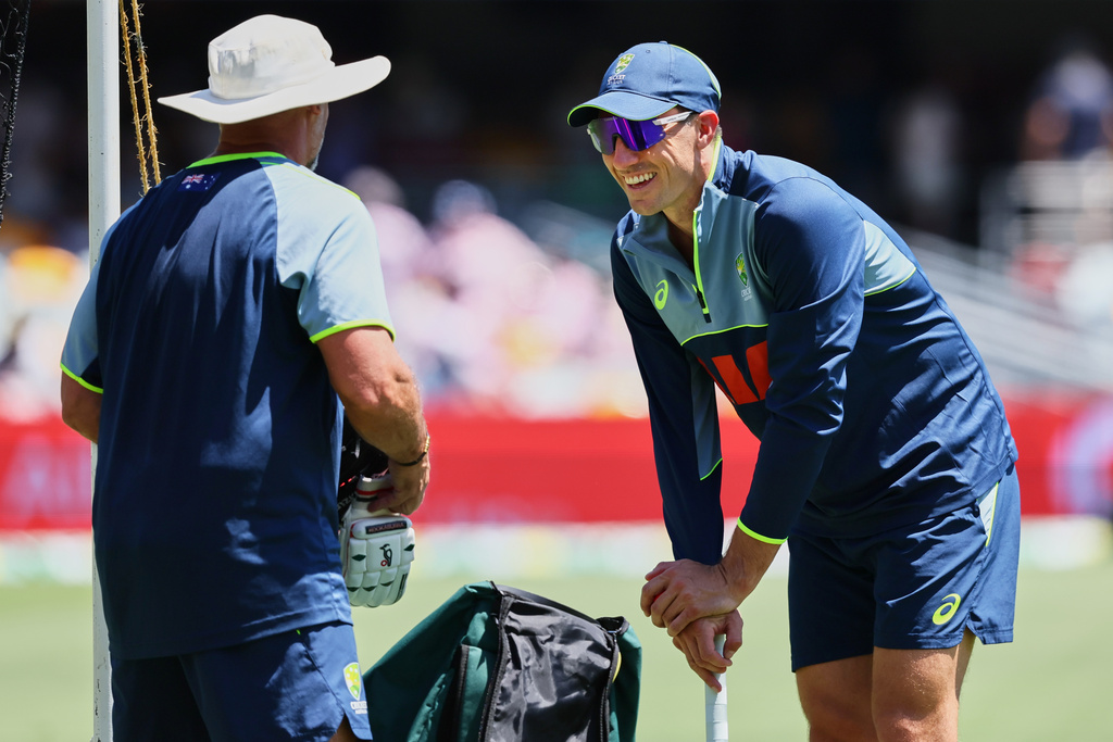 Australia's Pat Cummins, right, warms up before start of the second Ashes cricket test match between Australia and England in Brisbane, Thursday, Dec. 4, 2025.. (AP Photo/Tertius Pickard)