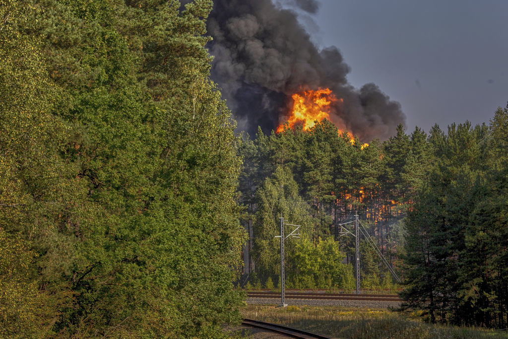 Smoke and flames rise following powerful explosions after several rail cars loaded with liquefied gas caught fire in the suburbs of Vilnius, Lithuania, Wednesday, Sept. 10, 2025. (AP Photo/Mindaugas Kulbis)