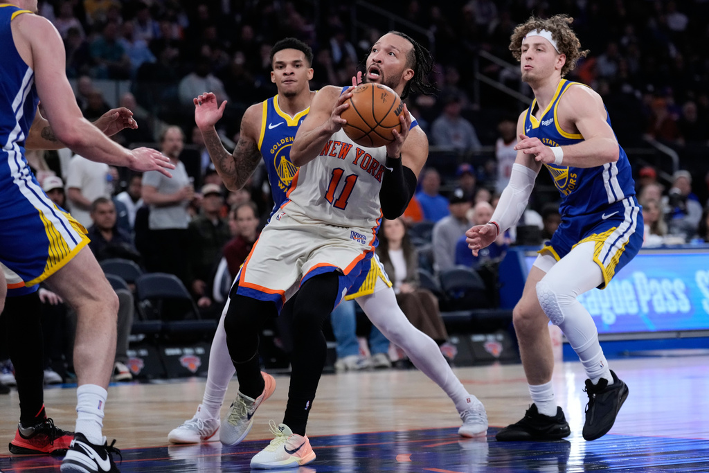 New York Knicks' Jalen Brunson, center, drives to the basket during the second half of an NBA basketball game against the Golden State Warriors Sunday, March 15, 2026, in New York. (AP Photo/Seth Wenig)
