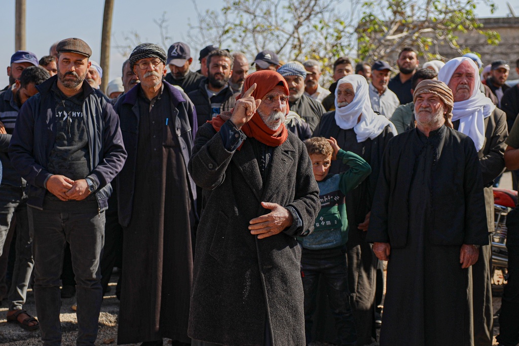 An elderly man speaks during the funeral of two women and a man killed when gunmen on motorcycles fired on a van near the Druze village of Kafr Maris, Syria's Idlib province, Wednesday, Oct. 22, 2025. (AP Photo/Omar Albam)