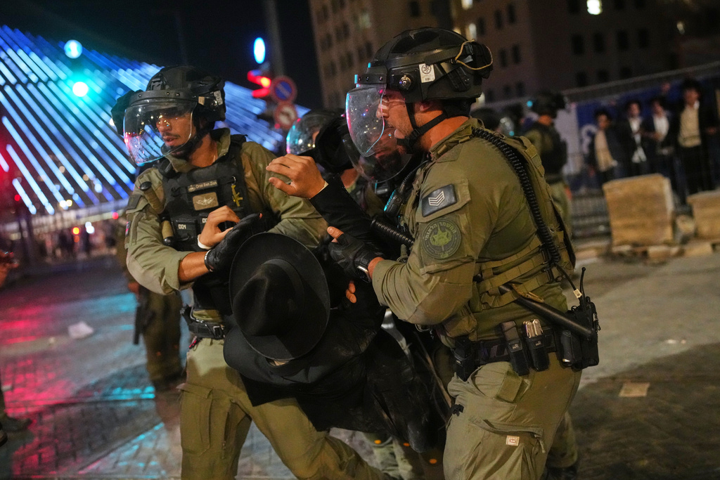 Israeli police officers disperse ultra-Orthodox Jewish men blocking a road during a protest against plans to require them to serve in the Israeli military, in Jerusalem, Thursday, Oct. 30, 2025. (AP Photo/Ohad Zwigenberg)