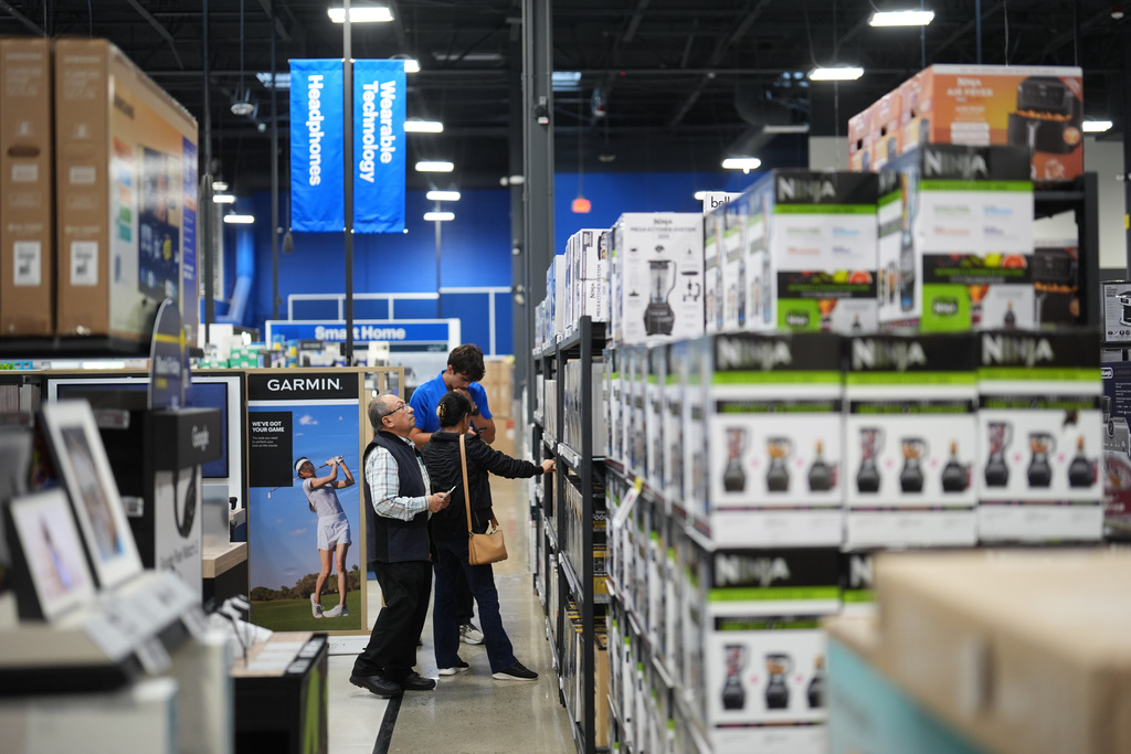 People shop among early Black Friday sale items at Best Buy Thursday, Nov. 20, 2025, in San Diego. (AP Photo/Gregory Bull)