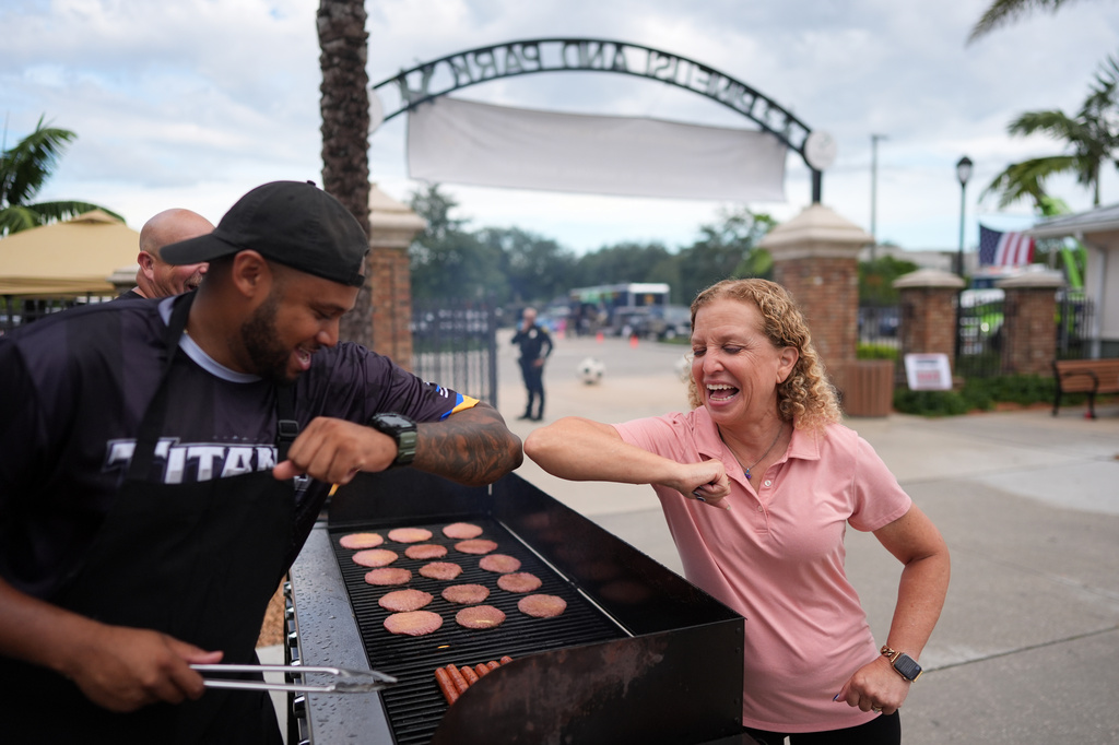 Rep. Debbie Wasserman Schultz, D-Fla., greets a man tending to a grill as she visits a National Night Out community event while campaigning for Florida's 20th congressional district, in Plantation, Fla., Tuesday, Aug. 4, 2026. (AP Photo/Rebecca Blackwell).
