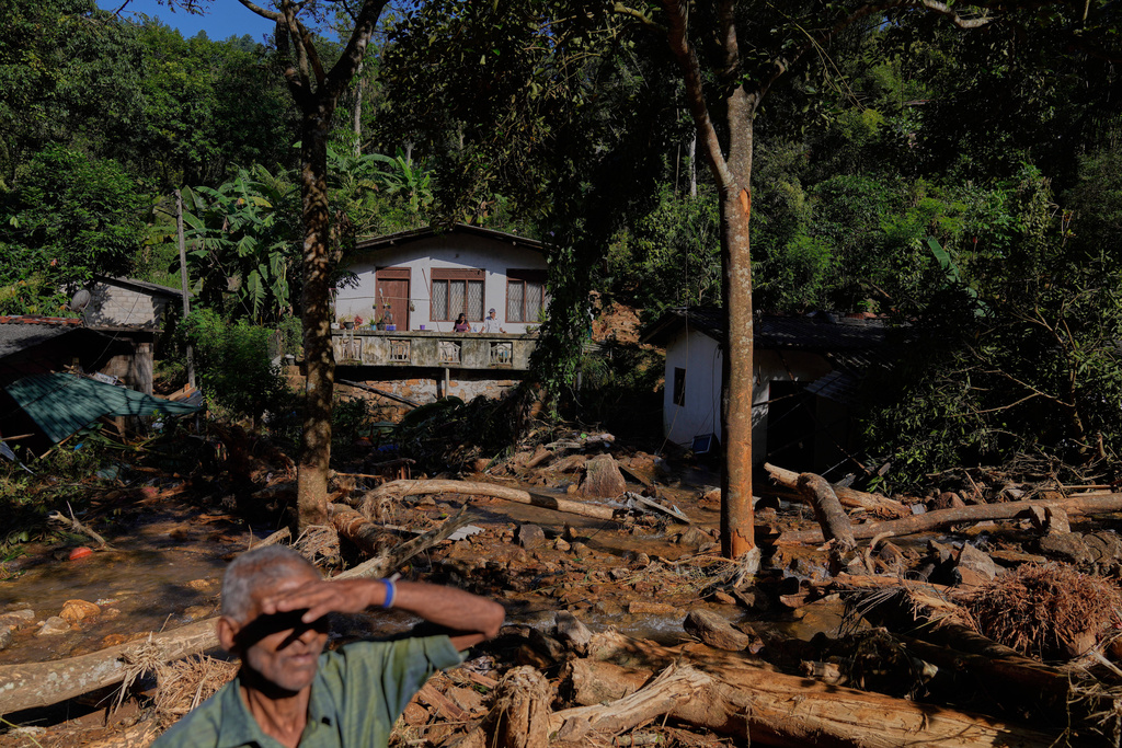 Landslide survivors look at the damages caused by the rain and landslides in Sarasavigama village in Kandy, Sri Lanka, Monday, Dec. 1, 2025. (AP Photo/Eranga Jayawardena)