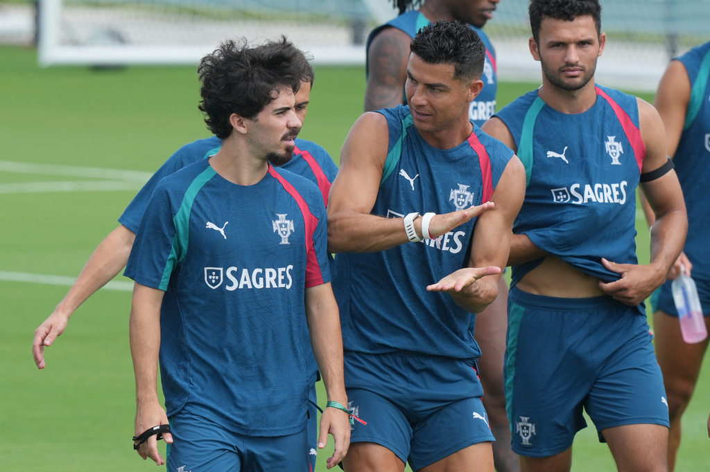 Portugal's Cristiano Ronaldo, center talks to Vitinha during the men's national soccer team World Cup training session Thursday, June 25, 2026, in Palm Beach Gardens, Fla. (AP Photo/Marta Lavandier)