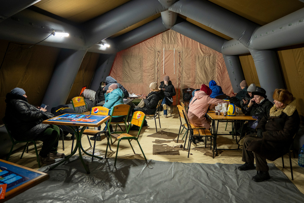 People get warm and charge their batteries in a tent set up by the emergency service following Russia's regular air attacks against the country's energy objects, in Kyiv, Ukraine, Tuesday, Jan. 13, 2026. (AP Photo/Danyil Bashakov)