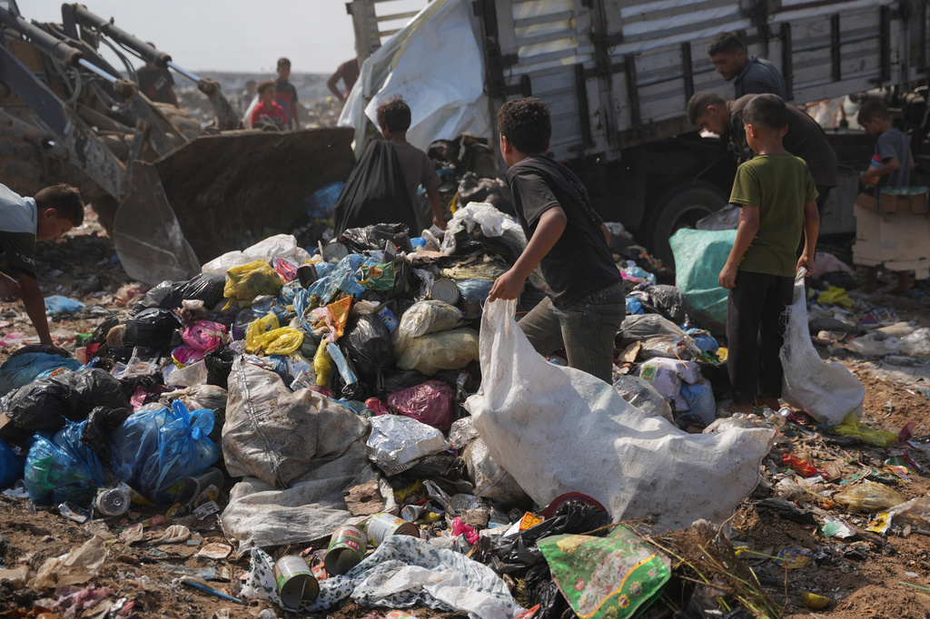 Palestinians search through a garbage dump for combustible materials to use as fuel for cooking due to a shortage of cooking gas, in Deir al-Balah, central Gaza Strip, Saturday, Aug. 22, 2026. (AP Photo/Abdel Kareem Hana)