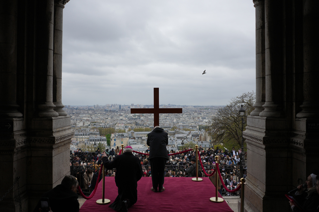 The cross is presented to the faithful during the Way of Cross ceremony to mark Good Friday, outside the Sacre Coeur basilica, Friday, April 3, 2026, in Paris. (AP Photo/Thibault Camus)