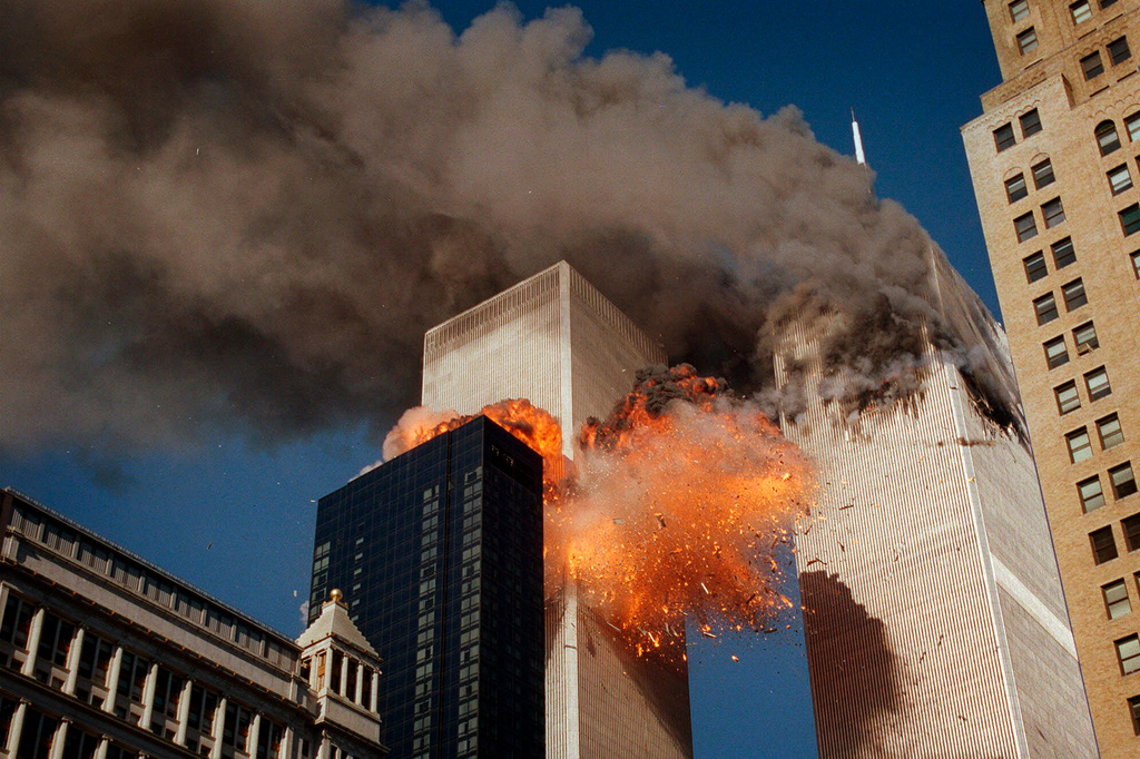 FILE - Smoke billows from one of the towers of the World Trade Center as flames and debris explode from the second tower, Sept. 11, 2001. (AP Photo/Chao Soi Cheong, File)