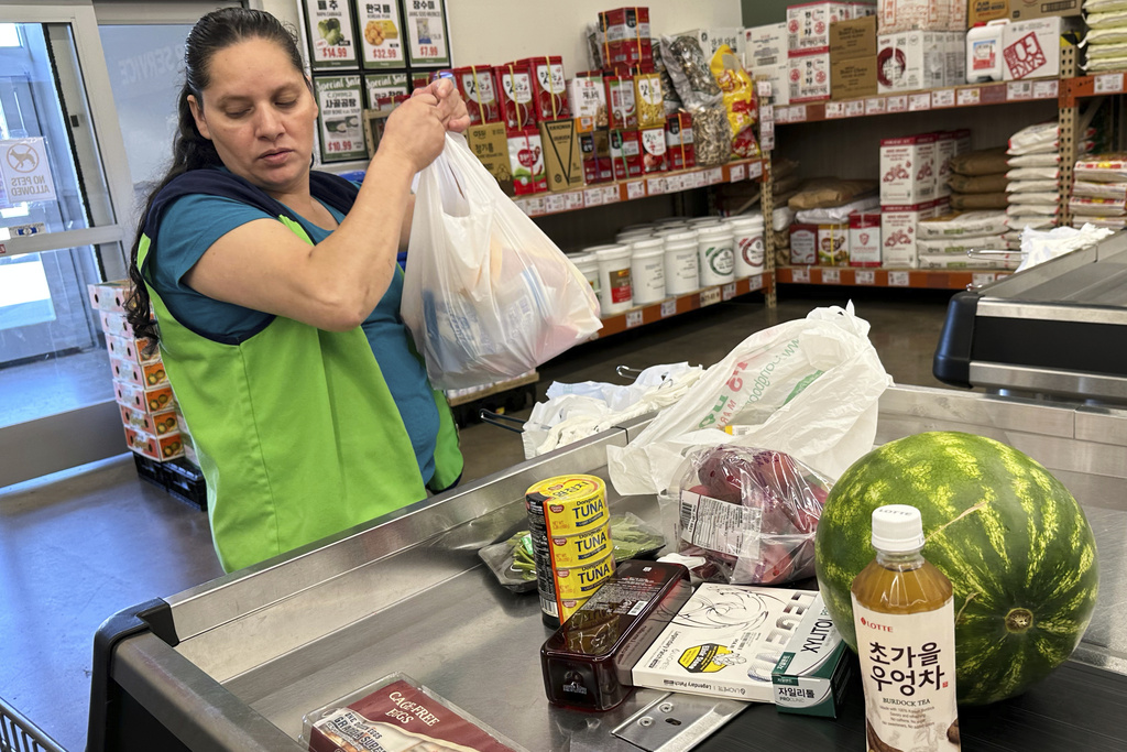 An employee works at a cash register in a grocery store in Schaumburg, Ill., Thursday, Sept. 18, 2025. (AP Photo/Nam Y. Huh)