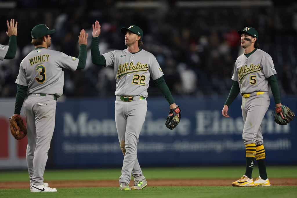 The Athletics' including Max Muncy (3) and Jeff McNeil (22) celebrate a win after the ninth inning of a baseball game against the New York Yankees, Wednesday, April 8, 2026, in New York. (AP Photo/Heather Khalifa)