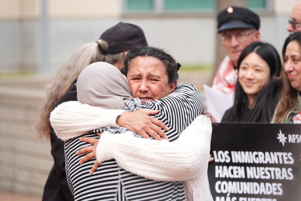 Immigrant-rights activist Jeanette Vizguerra, right, is hugged before she speaks after she was released on bond following nine months in an immigration detention center as supporters staged a rally for her outside the federal courthouse Tuesday, Dec. 23, 2025, in Denver. (AP Photo/David Zalubowski)