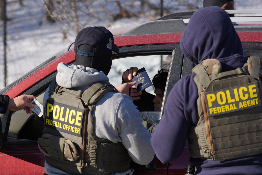 Federal agents make a traffic stop on a U.S. citizen as they provide their identification including a passport and drivers license, Tuesday, Jan. 27, 2026, in Minneapolis. (AP Photo/Adam Gray)