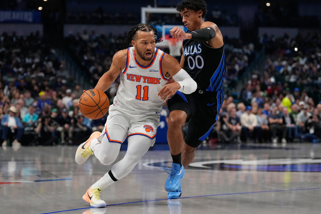 New York Knicks guard Jalen Brunson (11) dribbles against Dallas Mavericks guard Max Christie (00) in the first half of an NBA basketball game Wednesday, Nov. 19, 2025, in Dallas. (AP Photo/Tony Gutierrez)