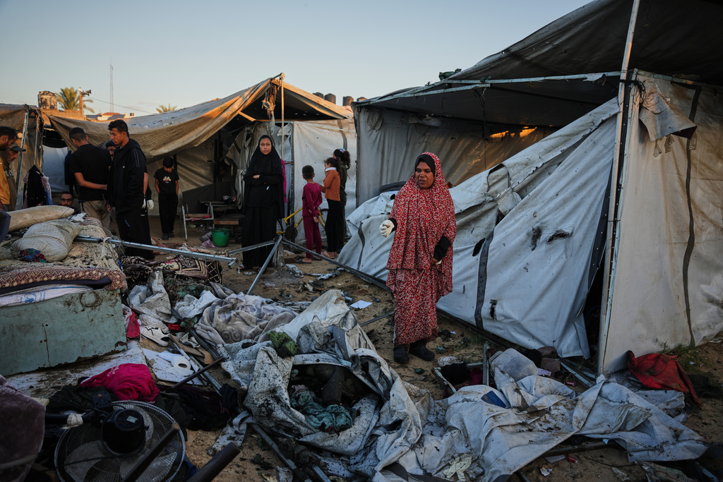 Displaced Palestinians inspect the damage after an Israeli army strike on their tent camp in Deir al-Balah, Gaza Strip, Wednesday, Oct. 29, 2025. (AP Photo/Abdel Kareem Hana)