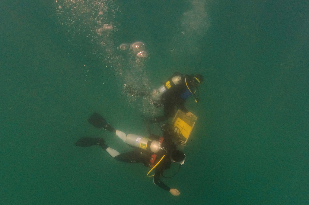 Divers place mock munitions on the floor of the Mediterranean Sea off the coast of Rishon LeZion, Israel, Sunday, June 21, 2026. (AP Photo/Ariel Schalit)