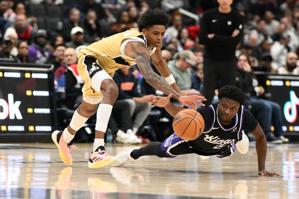 Sacramento Kings guard Isaiah Stevens, right, and Washington Wizards guard AJ Johnson, left, battle for the ball during the first half of an NBA basketball game, Sunday, Feb. 1, 2026, in Washington. (AP Photo/Nick Wass)