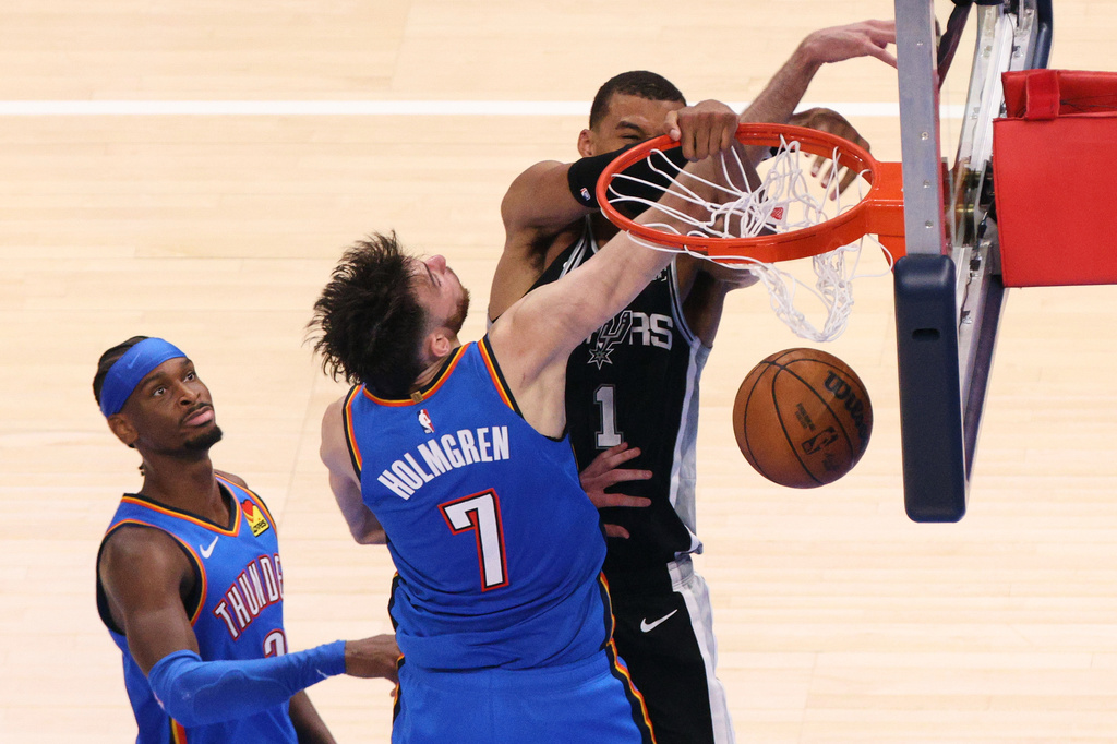 San Antonio Spurs forward Victor Wembanyama (1) dunks while being fouled by Oklahoma City Thunder center Chet Holmgren (7) during the second overtime of Game 1 in a third-round NBA basketball playoffs series Monday, May 18, 2026, in Oklahoma City. (AP Photo/Nate Billings)