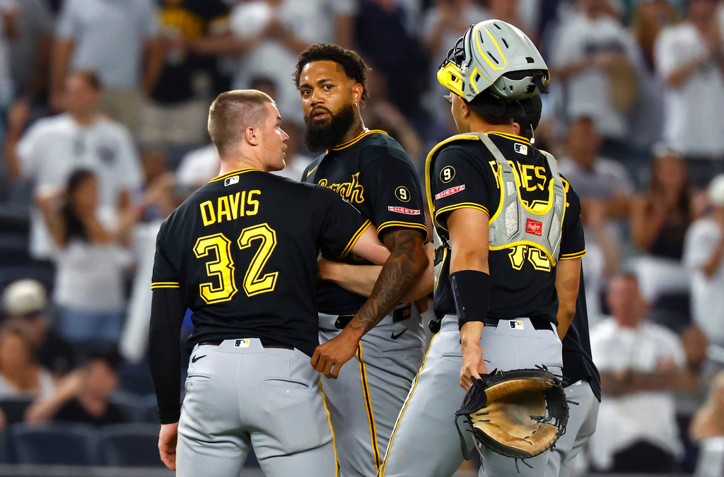 Pittsburgh Pirates catchers Henry Davis (32) and Rafael Flores Jr. keep pitcher Dennis Santana from going after New York Yankees' José Caballero during the ninth inning of a baseball game, Monday, July 20, 2026 in New York. (AP Photo/Noah K. Murray)