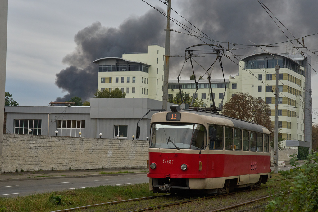 A public tram runs against the background of rising smoke during Russia's massive drone and missile attack in Kyiv, Ukraine, Sunday, Sept. 28, 2025. (AP Photo/Efrem Lukatsky)