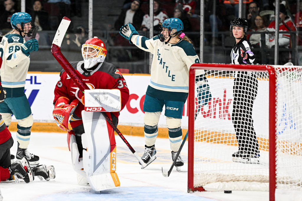 Seattle Torrent's Jessie Eldridge, right, celebrates her goal on Ottawa Charge goaltender Gwyneth Philips (33) during the second period of an PWHL hockey game in Ottawa, Ontario, Wednesday, March 4, 2026. (Spencer Colby/The Canadian Press via AP)