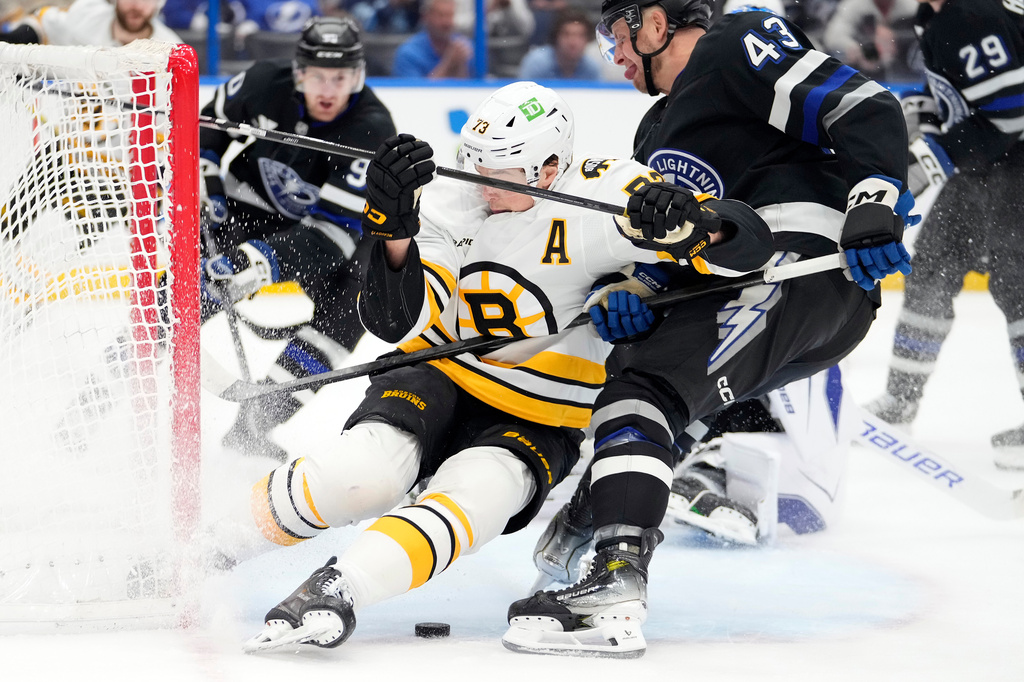Tampa Bay Lightning defenseman Darren Raddysh (43) takes down Boston Bruins defenseman Charlie McAvoy (73) during the first period of an NHL hockey game Saturday, April 4, 2026, in Tampa, Fla. (AP Photo/Chris O'Meara)