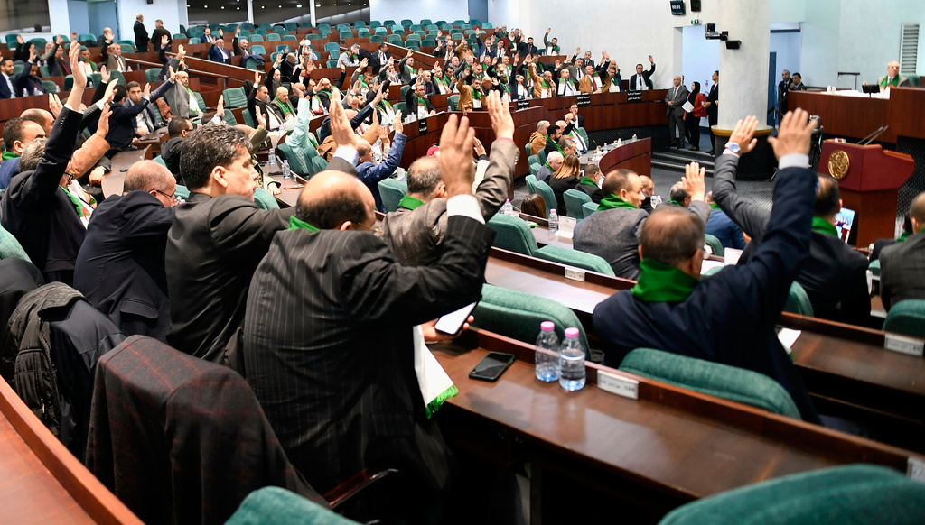 Parliament members vote on a bill seeking to criminalize France's colonisation, considering it a "state crime," and demanding that France issue an official apology and take legal responsibility for its colonial past in addition to compensations, Wednesday, Dec. 24, 2025 at her National Assembly in Algiers. (AP Photo/Fateh Guidoum)