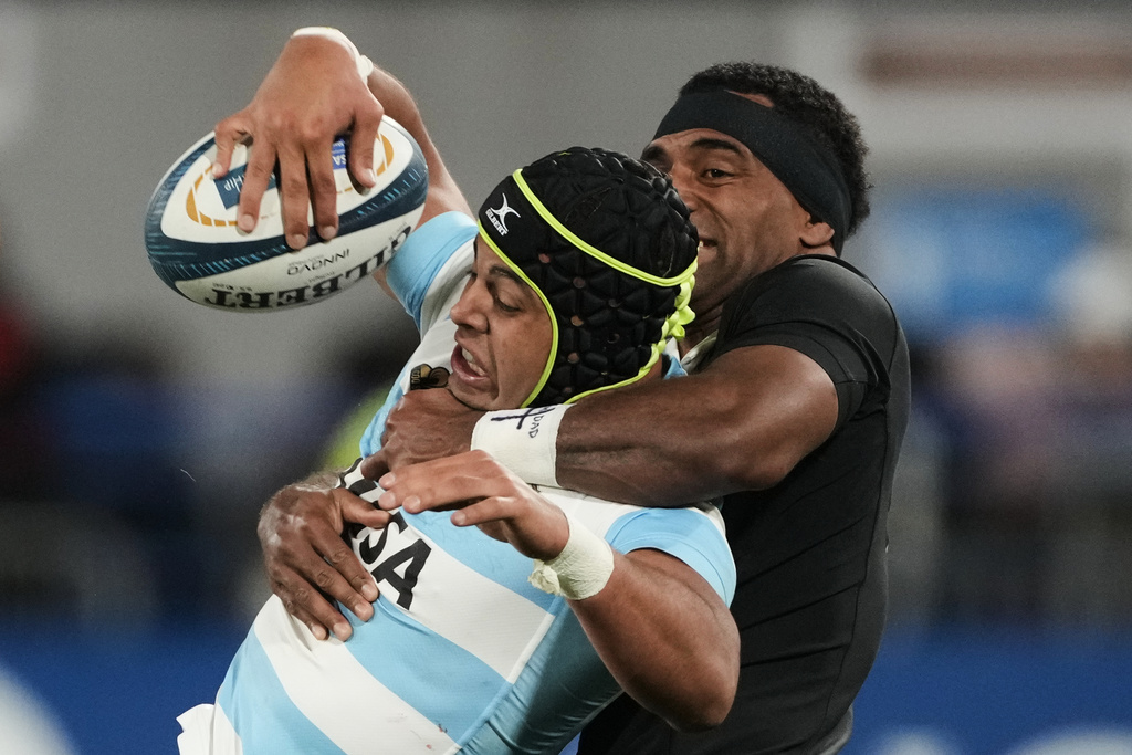 Argentina's Los Pumas Santiago Chocobares is tackled by New Zealand's All Blacks Sevu Reece during a rugby championship match in Buenos Aires, Aug. 23, 2025. (AP Photo/Gustavo Garello)