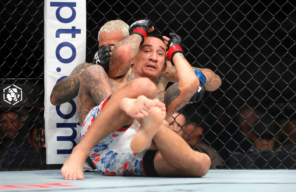 Max Holloway, foreground, grapples with Charles Oliveira in a lightweight fight during UFC 326 Saturday, March 7, 2026, in Las Vegas. (Steve Marcus/Las Vegas Sun via AP)