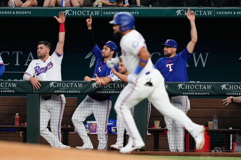 Texas Rangers players celebrate after Ezequiel Duran, front, hit a solo home run in the third inning of a baseball game against the Seattle Mariners in Arlington, Texas, Monday, July 27, 2026. (AP Photo/Tony Gutierrez)