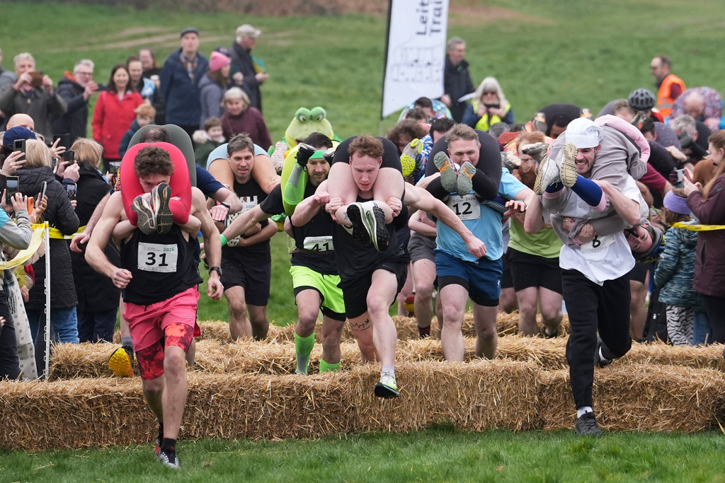 People take part in the annual UK Wife Carrying Race in Dorking, England, Sunday March 8, 2026. (Gareth Fuller/PA via AP)