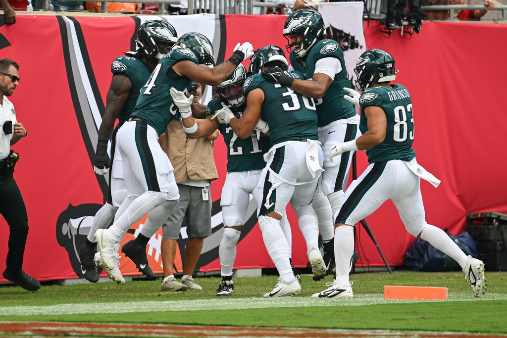 Philadelphia Eagles teammates surround safety Sydney Brown (21) as they celebrate his touchdown during the first half of an NFL football game against the Tampa Bay Buccaneers, Sunday, Sept. 28, 2025, in Tampa, Fla. (AP Photo/Jason Behnken)