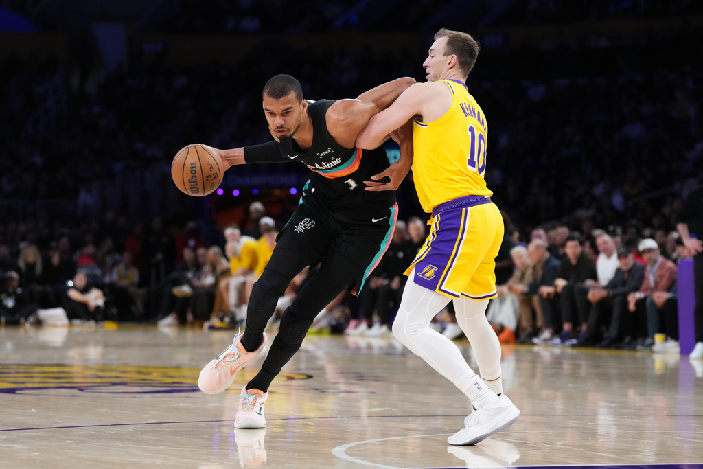San Antonio Spurs forward Victor Wembanyama (1) works around Los Angeles Lakers guard Luke Kennard (10) during the first half of an NBA basketball game Tuesday, Feb. 10, 2026, in Los Angeles. (AP Photo/Jae C. Hong)