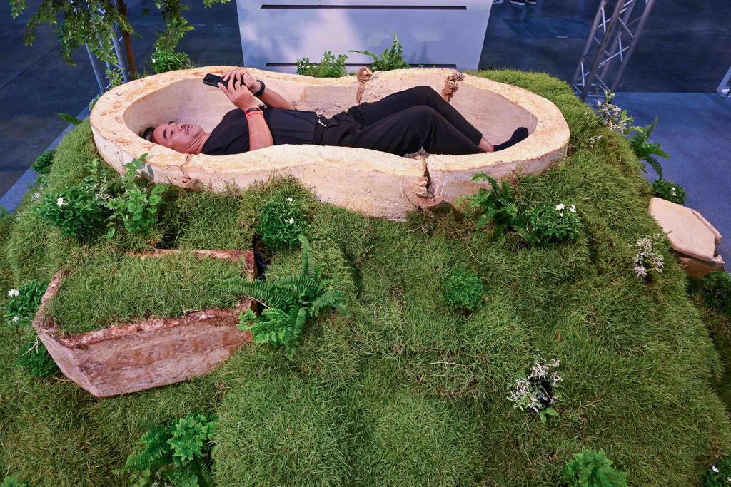 A Visitor lies inside a coffin made of mycelium, the rootlike fibers of fungi, at Death Fest in Nonthaburi, Thailand, Friday, March 13, 2026. (AP Photo/Kittinun Rodsupan)
