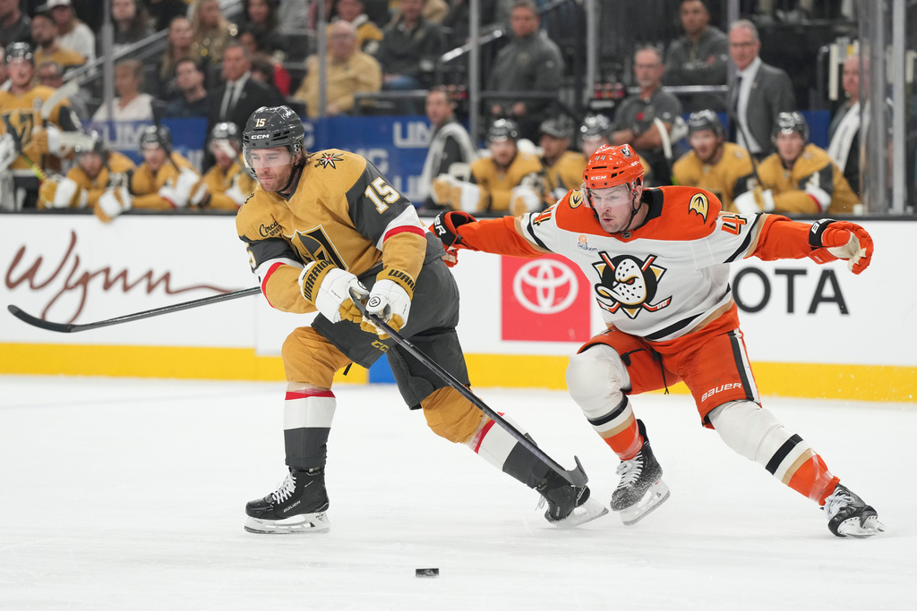 Vegas Golden Knights defenseman Noah Hanifin (15) skates with the puck against Anaheim Ducks left wing Ross Johnston (44) in the first period of an NHL hockey game Saturday, Nov. 8, 2025, in Las Vegas. (AP Photo/Candice Ward)