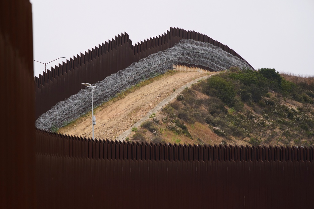 FILE - Concertina wire lines the interior of a border wall separating Tijuana, Mexico, from the United States, June 4, 2025, in San Diego. (AP Photo/Gregory Bull, File)
